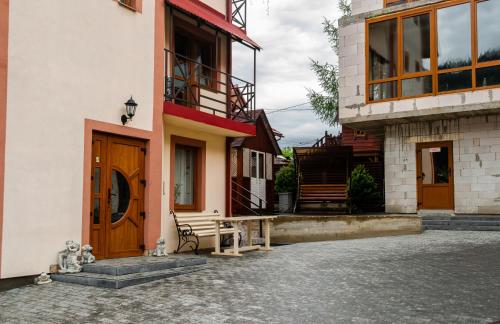 ein Gebäude mit einer Holztür und einem Balkon in der Unterkunft Melody Hotel in Bukowel