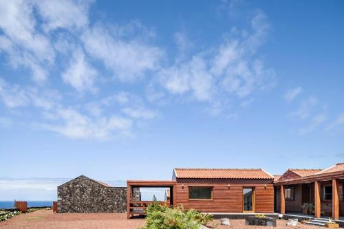 a wooden house with a sky background at Alma do Pico - Nature Residence in Madalena