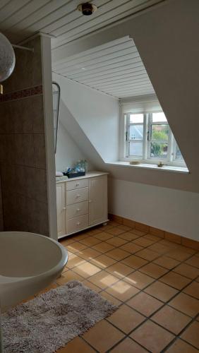 an attic bathroom with a tub and a window at Room in Ubby (Near Kalundborg) in Kalundborg