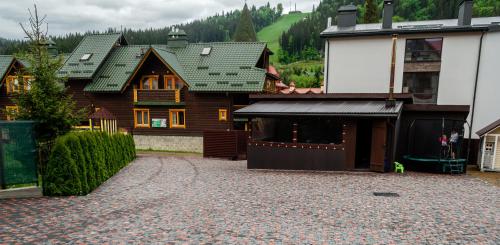 ein Haus mit einer Auffahrt vor einem Gebäude in der Unterkunft Melody Hotel in Bukowel