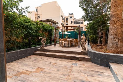 a garden with two statues of people on a patio at Suite 1 at Palazzo Seraphim Boutique living in St Julians in St. Julianʼs