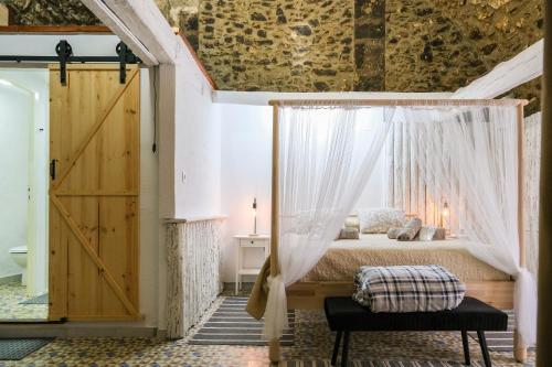 1 dormitorio con cama con dosel y ventana en Alojamiento Rural Can Picas, en Cantallops