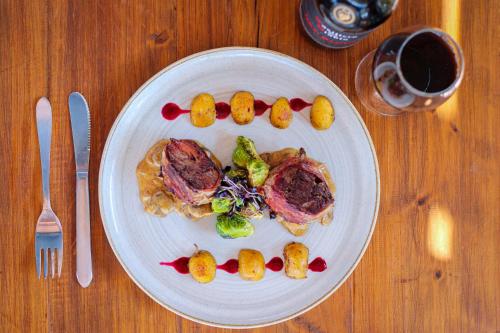 a plate of food with meat and vegetables on a table at Hotel Campestre Ataraxia Barichara in Barichara