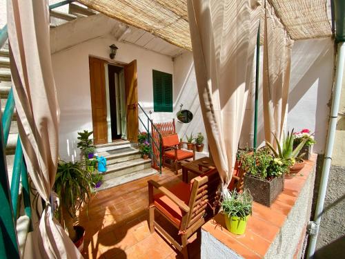a porch with chairs and potted plants on it at Urban garden in Manciano