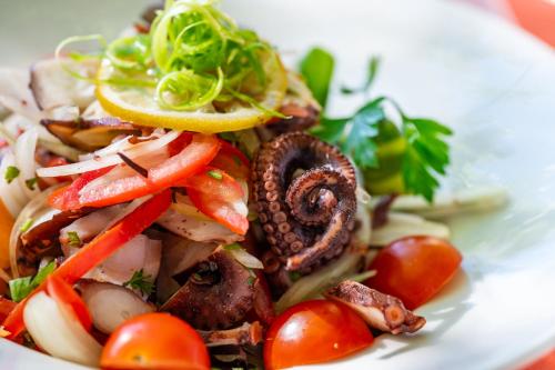 a white plate of food with vegetables on it at Hotellerie du Domaine de Cabasse in Séguret
