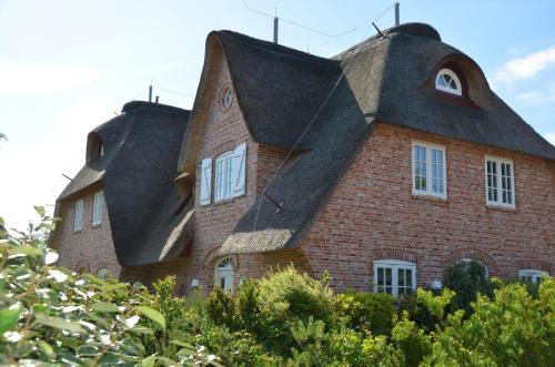 a large brick building with a thatched roof at Litzkow 11205 in Morsum