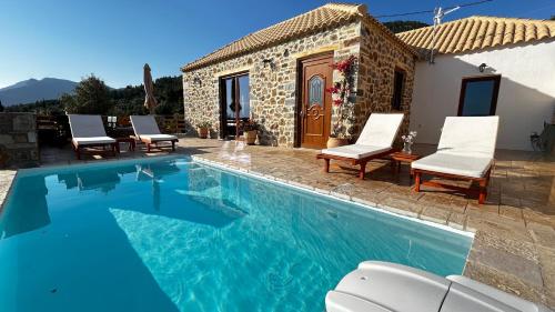 a villa with a swimming pool in front of a house at Cassiopea Guest House Evia Greece in Nerotriviá