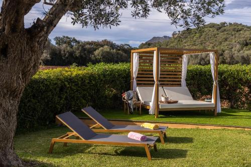 a couple of chairs and a swing in a yard at Villa Almadrava - Puerto Pollensa - Llenaire in Pollença
