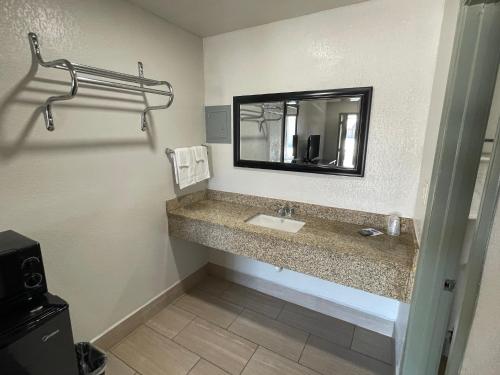 La salle de bains est pourvue d'un lavabo et d'un miroir. dans l'établissement Budget Inn Ada, à Ada