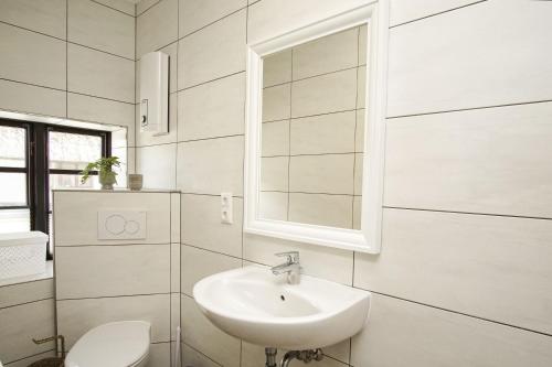 a white bathroom with a sink and a toilet at Haus Büdnerstube Ferienwohnung Nr 3 - mit Schwimmbad und Saunanutzung im AHOI-Erlebnisbad Sellin in Middelhagen