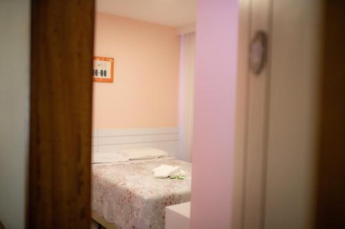 a small bedroom with a bed in a room at Hotel Paradouro in Barracão
