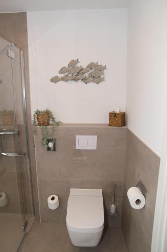 a small bathroom with a toilet and a shower at Sieltied in Greetsiel