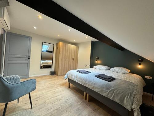 une chambre avec un grand lit et une chaise dans l'établissement Appartement proche de Paris, à Aulnay-sous-Bois