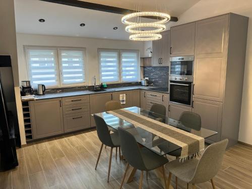 une cuisine avec une table en verre et des chaises. dans l'établissement Appartement proche de Paris, à Aulnay-sous-Bois