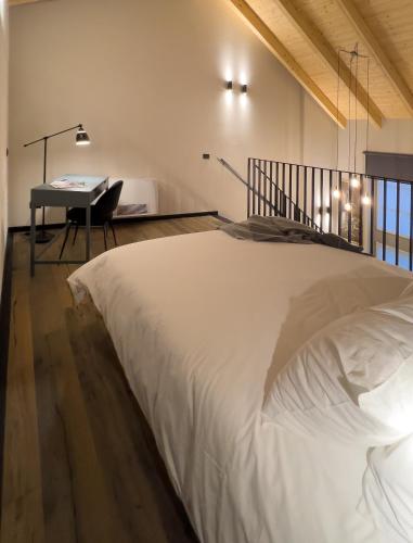 a bedroom with a large white bed and a desk at La Villa Viale Verdi in Novara