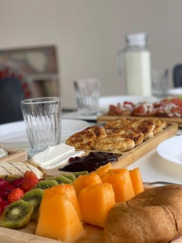 a table topped with different types of bread and fruit at House Pollo in Ksamil