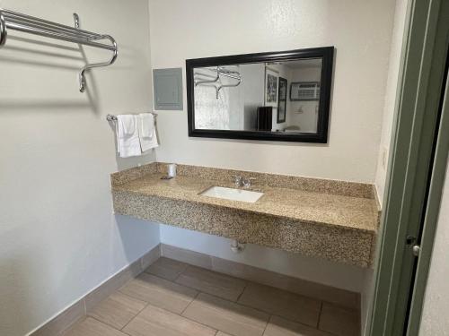 a bathroom with a sink and a mirror at Budget Inn Ada in Ada