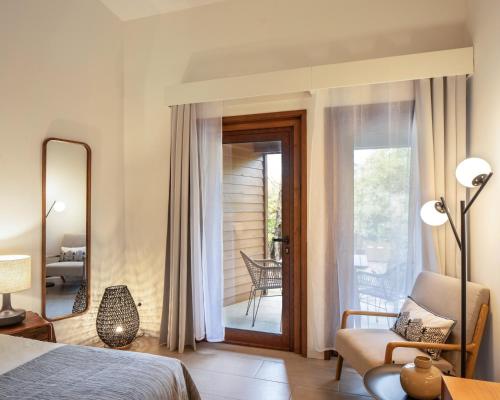 a bedroom with a bed and a chair and a mirror at Alma do Pico - Nature Residence in Madalena