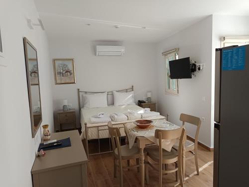 Habitación con cama, mesa y sillas. en Lythri Studios en Chios