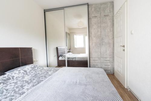 a bedroom with a bed and a large mirror at Daria Apartment in Bitola in Bitola