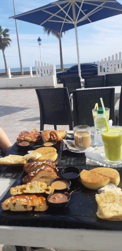 a table with a tray of breakfast foods on it at Appartement de Luxe Costa-Mar Martil Tetouan in Martil