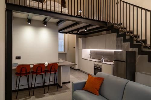 a kitchen and living room with a staircase in a loft at La Villa Viale Verdi in Novara