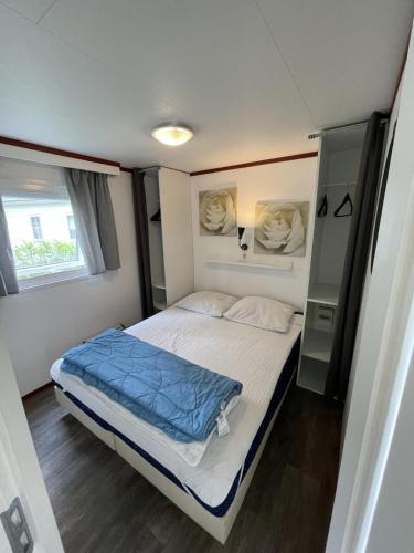 a small bedroom with a bed and a window at De pallegarste chalet 119 in Mariënberg