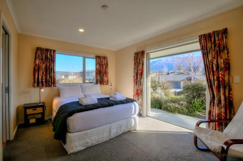 - une chambre avec un lit et une grande fenêtre dans l'établissement Lake Hawea Hideaway - Lake Hawea Holiday Home, à Lake Hawea