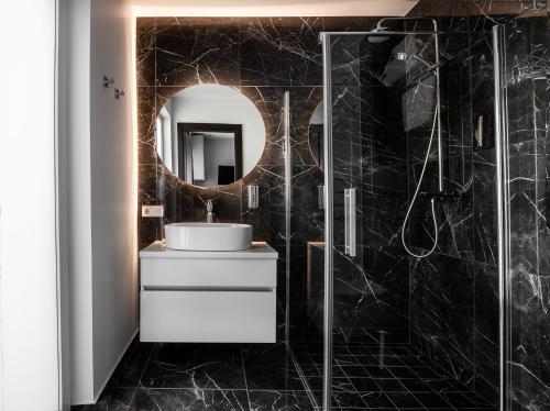 La salle de bains est pourvue d'un lavabo et d'un miroir. dans l'établissement Jono kalnelis Apartments, à Klaipėda