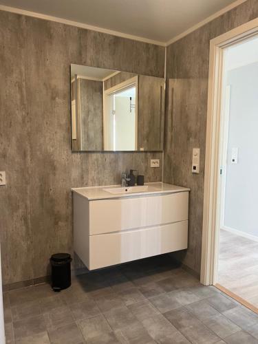 a bathroom with a white sink and a mirror at Mosjøen Romutleie - Sentrum 2 in Mosjøen