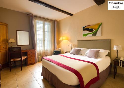 Pokój hotelowy z dużym łóżkiem i krzesłem w obiekcie Hotel d'Aragon w Montpellier