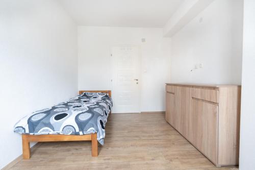 a bedroom with a bed and a wooden cabinet at Daria Apartment in Bitola in Bitola