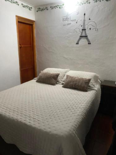 1 dormitorio con 1 cama con la torre Eiffel en la pared en La Casa de Taty en Valledupar