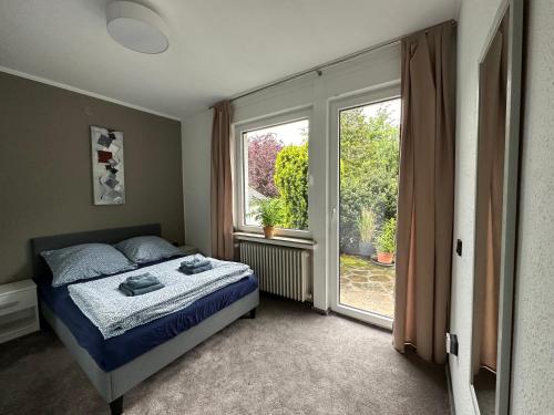 Entspannung am Niederrhein - großes helles Haus mit Kamin في إميريش: غرفة نوم بسرير ونافذة كبيرة