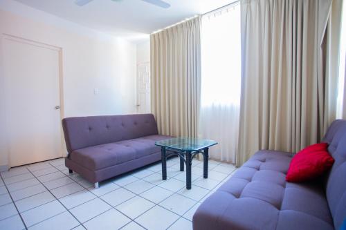 a living room with a couch and a glass table at Hotel Tropicus Boutique in Puerto Vallarta