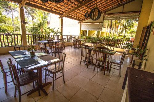 Solar Pipa - Solar da Gameleira Flats في بيبا: مطعم بطاولات وكراسي وساعة على السقف