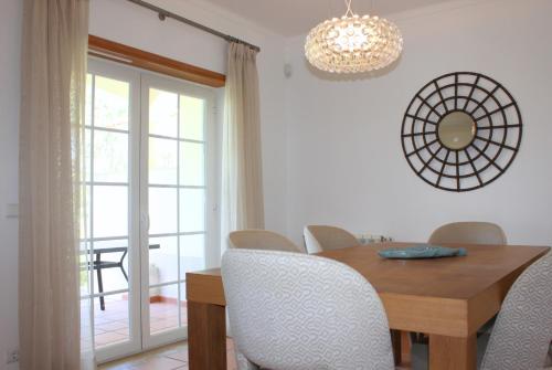a dining room with a wooden table and chairs at D. Duarte Townhouse in Casal da Lagoa Seca
