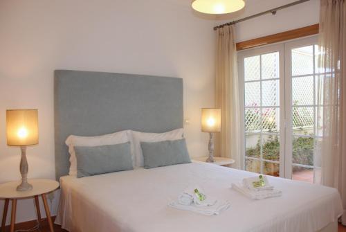 1 dormitorio con 1 cama blanca y 2 toallas en D. Duarte Townhouse, en Casal da Lagoa Seca