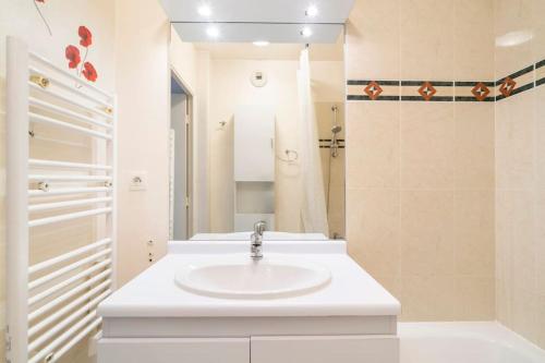 a white bathroom with a sink and a shower at Appartement avec Jardin et Terrasse près de Paris in Mantes-la-Jolie