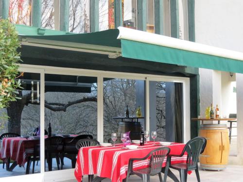 une terrasse avec une table et un tissu de table rouge dans l'établissement Maison typique Basque en pleine campagne, à Saint-Pée-sur-Nivelle