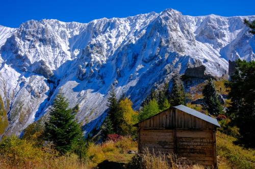 a wooden shack on a hill with mountains in the background at Khikhani Palace in Khulo