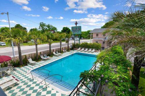 una piscina en un hotel con palmeras en The Starlight Motor Inn en Charleston