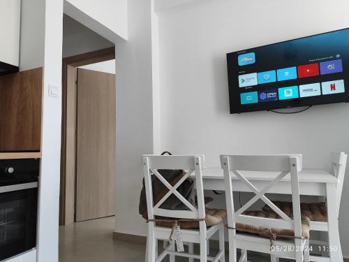 a kitchen with a table with two chairs and a tv at Stefanie Apartment 2 Peraia in Perea