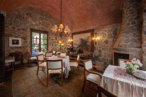 a dining room with tables and chairs and a fireplace at Posada del Angel in Antigua Guatemala