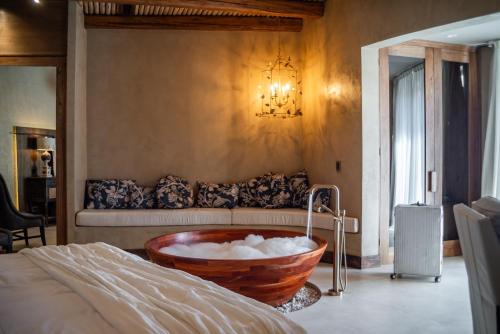 a bedroom with a bath tub with a couch at La Maria Hotel Boutique in Chacras de Coria