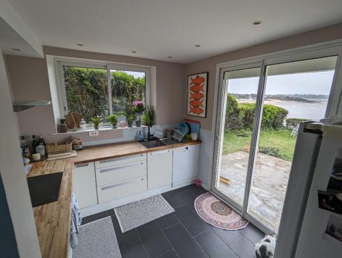 - une cuisine avec un évier et un comptoir avec une fenêtre dans l'établissement Coin de paradis inoubliable, à Lancieux