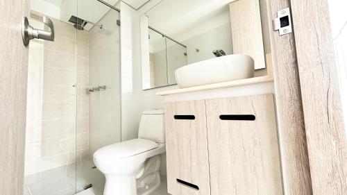 a bathroom with a toilet and a sink and a mirror at Apartamentos en Club Residencial in Ibagué