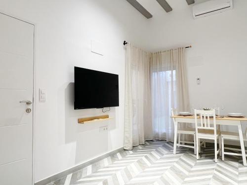 a white room with a table and a tv on a wall at Encantador apartamento vigas de madera in Valencia