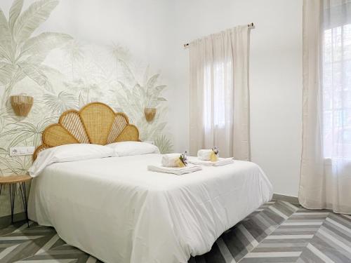 a bedroom with a large white bed with two dishes on it at Encantador apartamento vigas de madera in Valencia