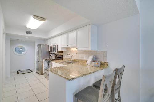 a kitchen with white cabinets and a counter top at Beachfront Condo in Gulf Shores with Pool Access! in Gulf Shores